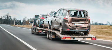 Abschleppwagen mit beschädigten Fahrzeugen nach einem Unfall, für Autoankauf Unfallwagen und Transport